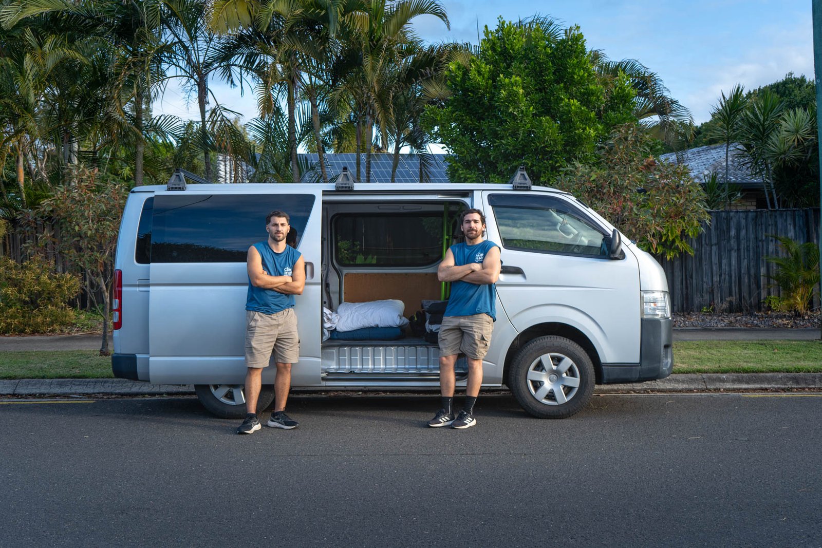 A new-build street in Sippy Downs, flat-pack boxes stacked on a front lawn, van in the driveway